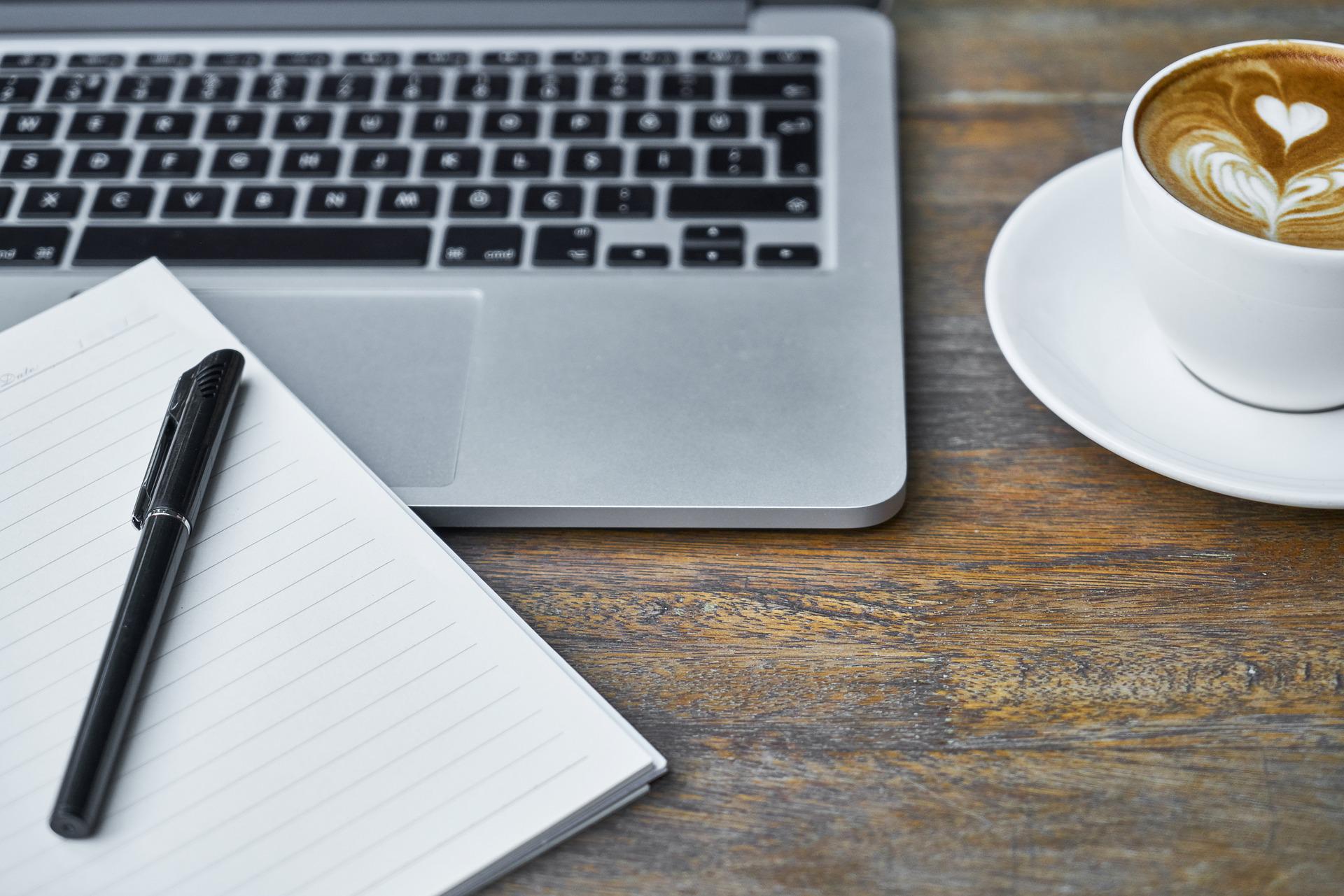 Image of notebook, laptop, and coffee cup.